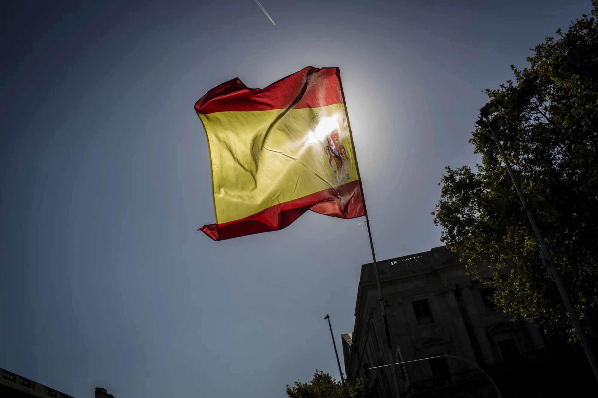 A Spanish national flag flies at the Pla de Palau square in Barcelona, Spain.