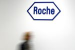 A company logo hangs on the wall at the Roche headquarters in Basel, Switzerland.