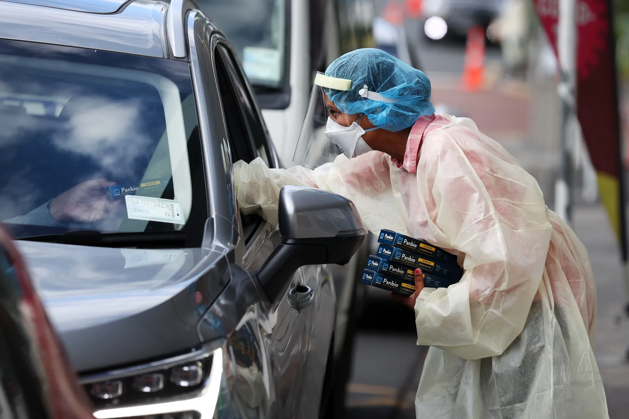 A healthcare worker hands out Rapid Antigen Tests in Auckland on Feb. 24.