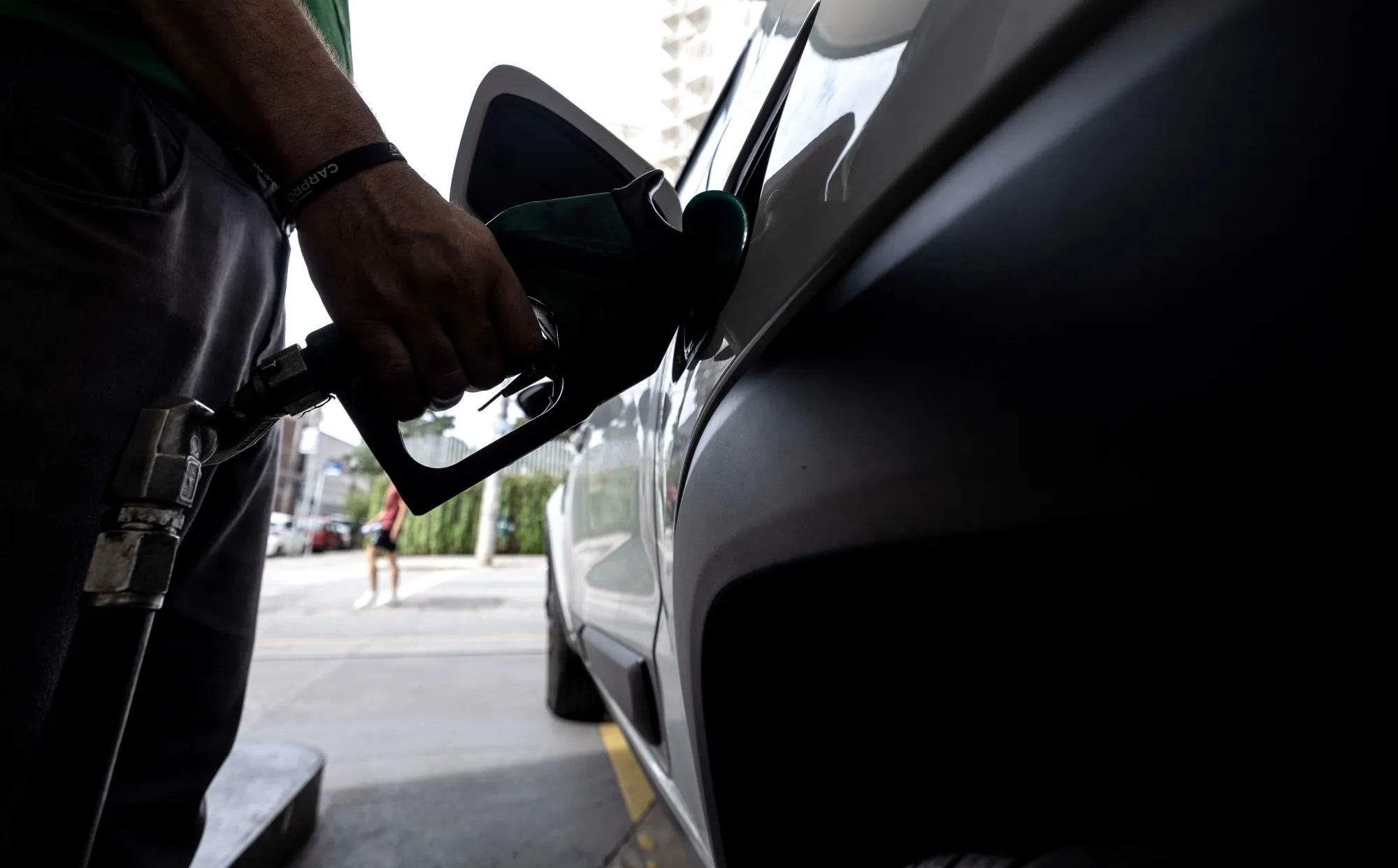 A worker refuels a vehicle at a gas station in Sao Paulo.