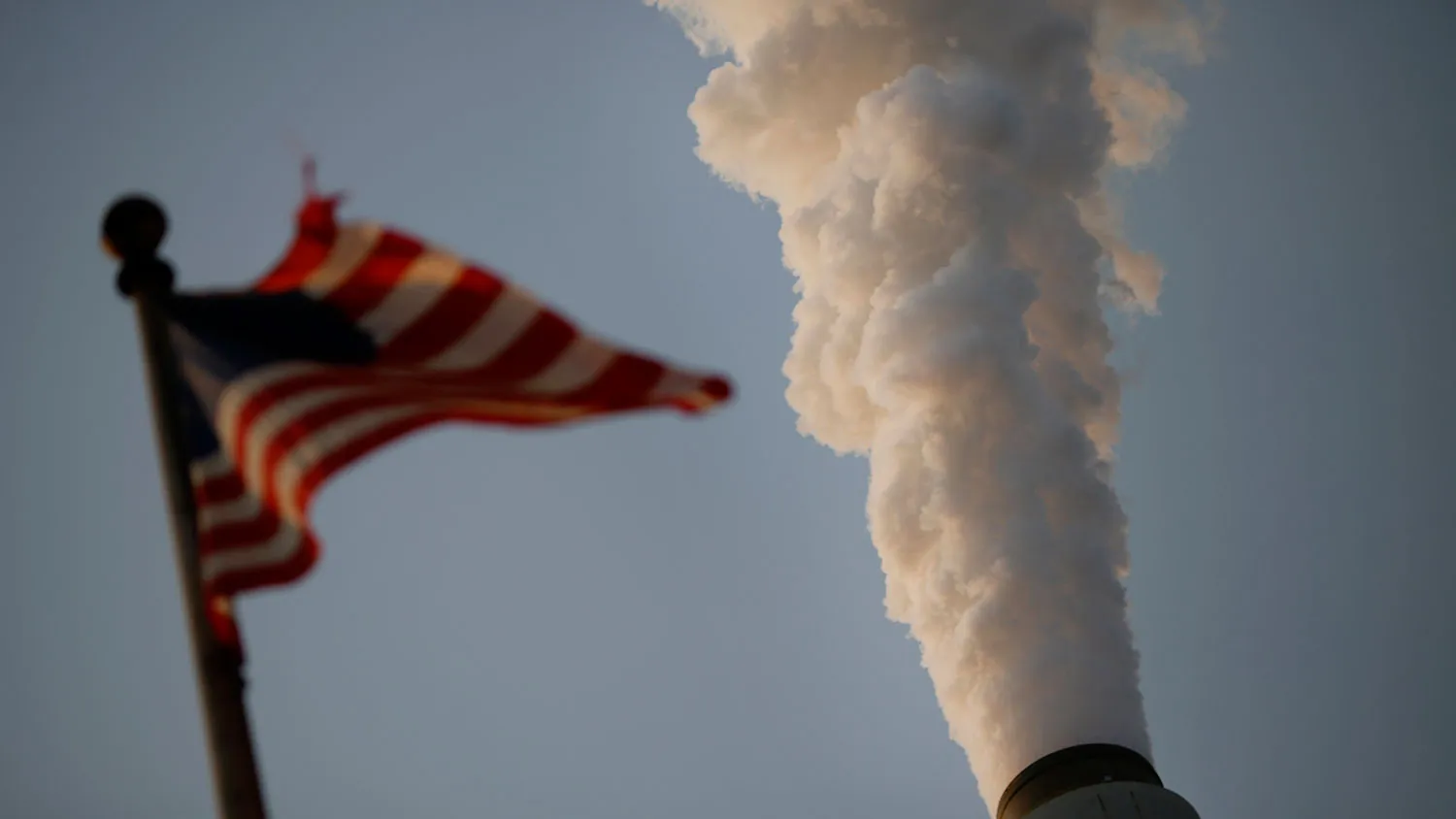 Emissions rise as a U.S. flag flies at the American Electric Power Co. Inc. coal-fired John E. Amos Power Plant in Winfield, West Virginia, U.S., on Thursday, July 31, 2014.
