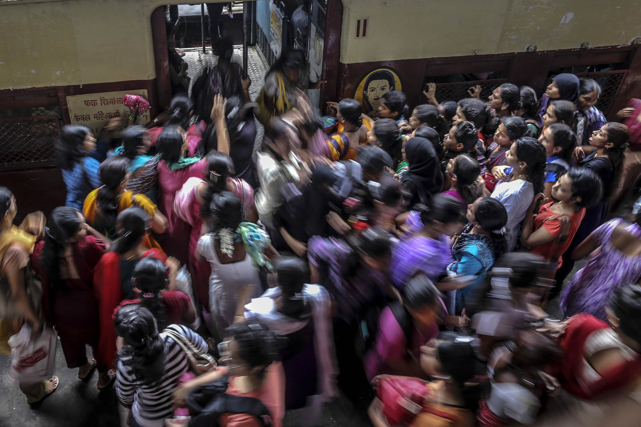 Commuters board a train at Kurla railway station during the morning rush hour in Mumbai.
