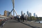 Morning commuters walk across Southgate Bridge as buildings stand in the central business district in Melbourne, Australia, on Tuesday, Feb. 10, 2015. The Australian Bureau of Statistics is scheduled to release monthly employment figures on Feb. 12.