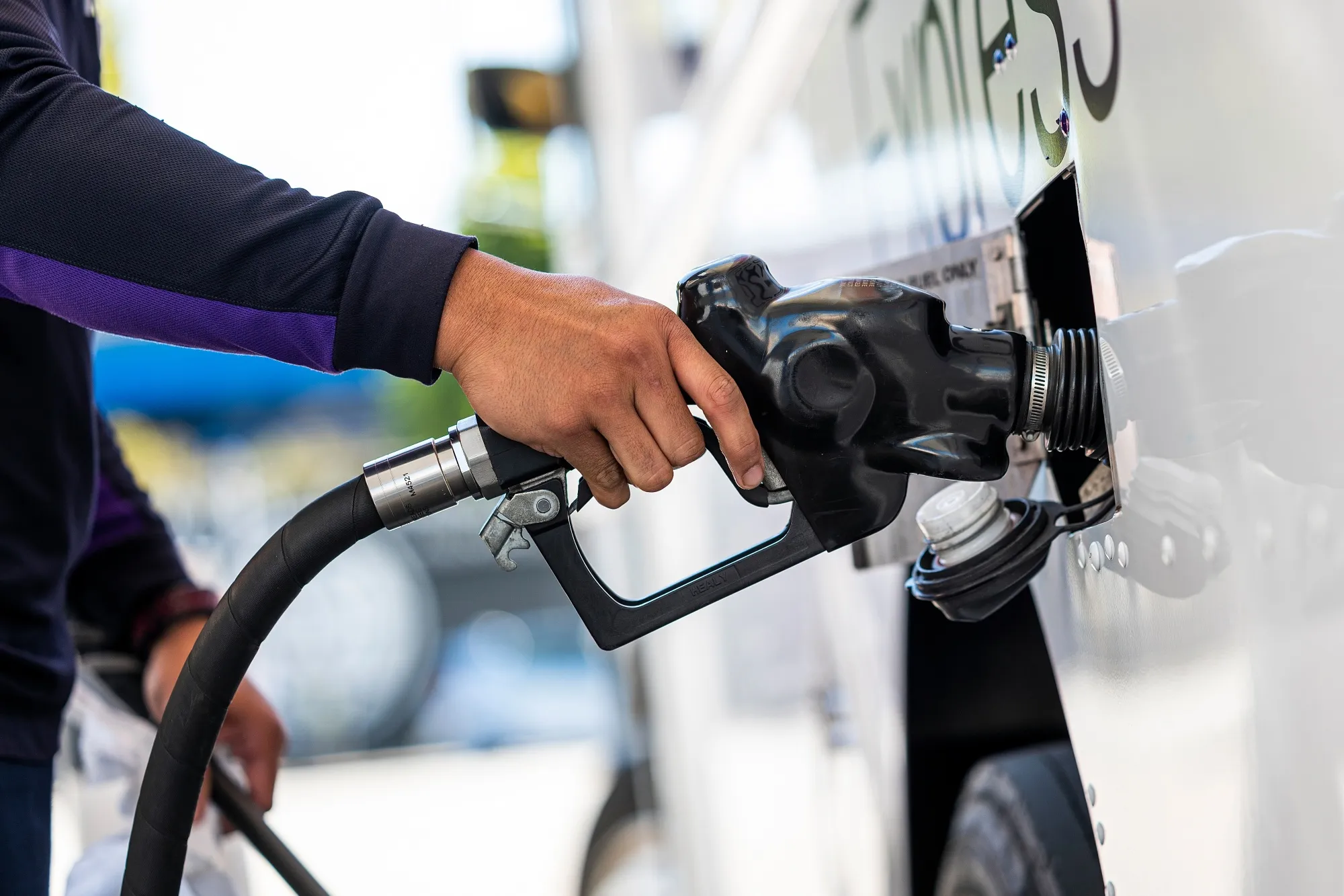 A worker refuels a truck at a gas station.&nbsp;