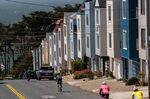 Cyclists ride past residential housing in San Francisco on&nbsp;April 9, 2021. New research shows rent prices in the city&nbsp;are still well below pre-pandemic projections.&nbsp;