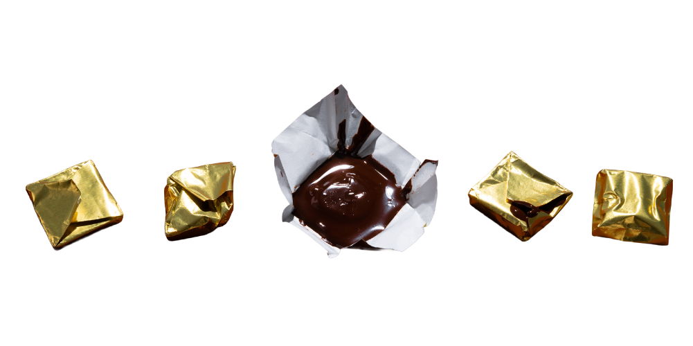 5 chocolate candies covered in gold wrapping. The one directly in the middle is opened and appears to be melting.