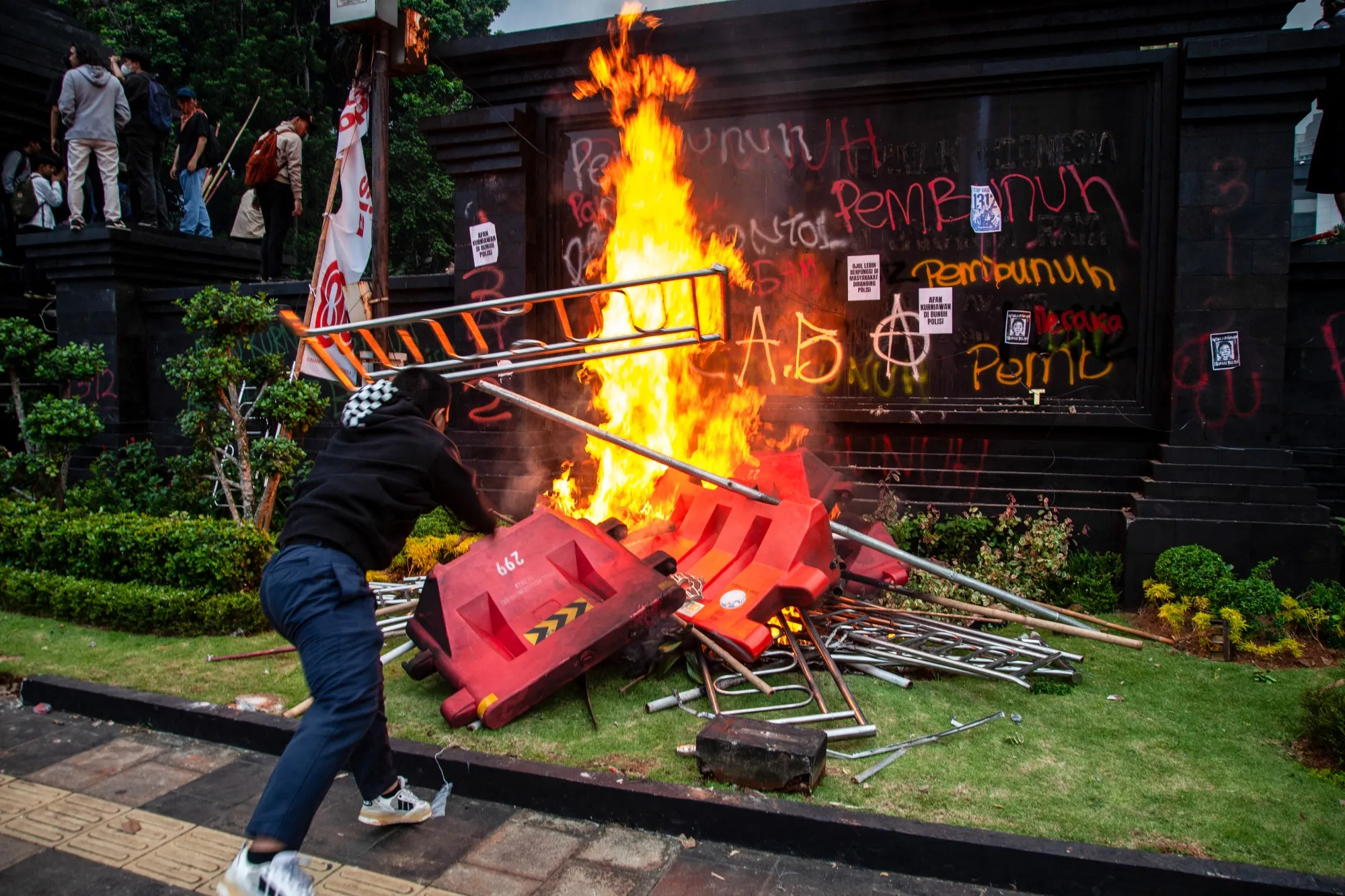 A demonstrator throws barricades into a fire during a protest in Jakarta on Aug. 29.