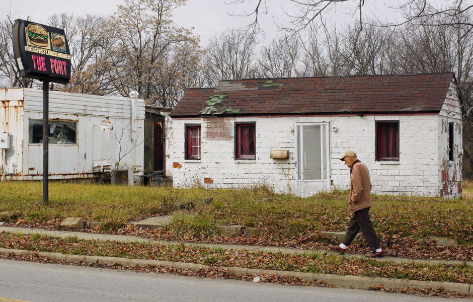 A man walks past a closed business in Youngstown, Ohio.