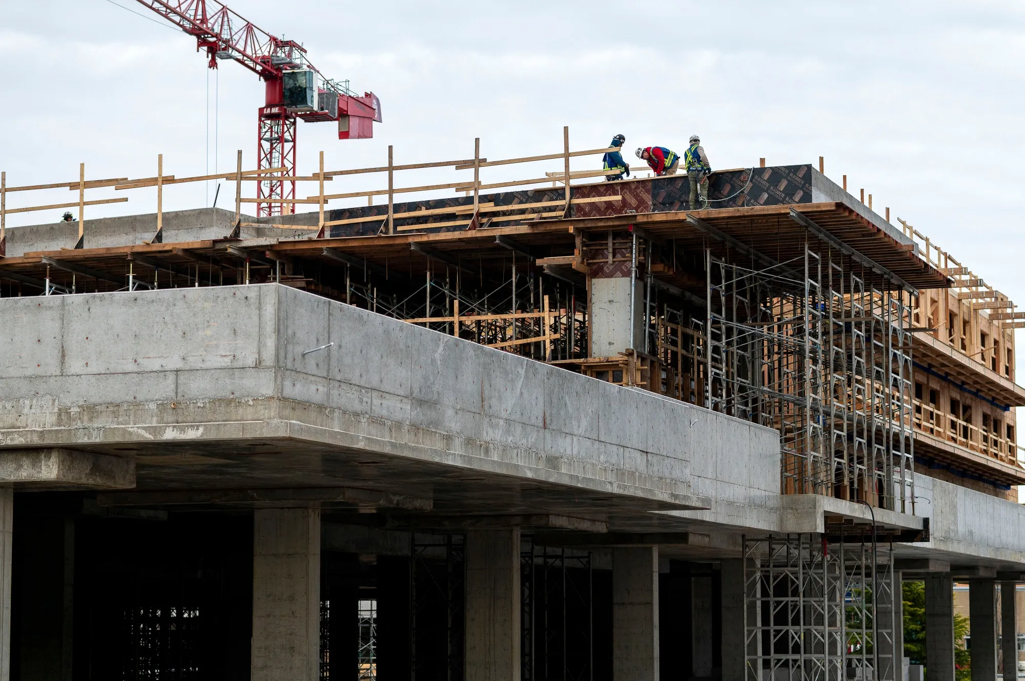 Workers on a mid-rise housing tower under construction in Victoria, British Columbia, Canada.