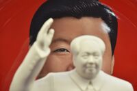 An image of Chinese President Xi Jinping is seen behind a statue of late communist leader Mao Zedong at a souvenir store next to Tiananmen Square in Beijing in 2018. 
