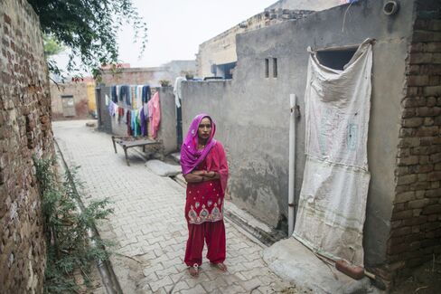 Kamlesh stands next to a community toilet in Lahli village