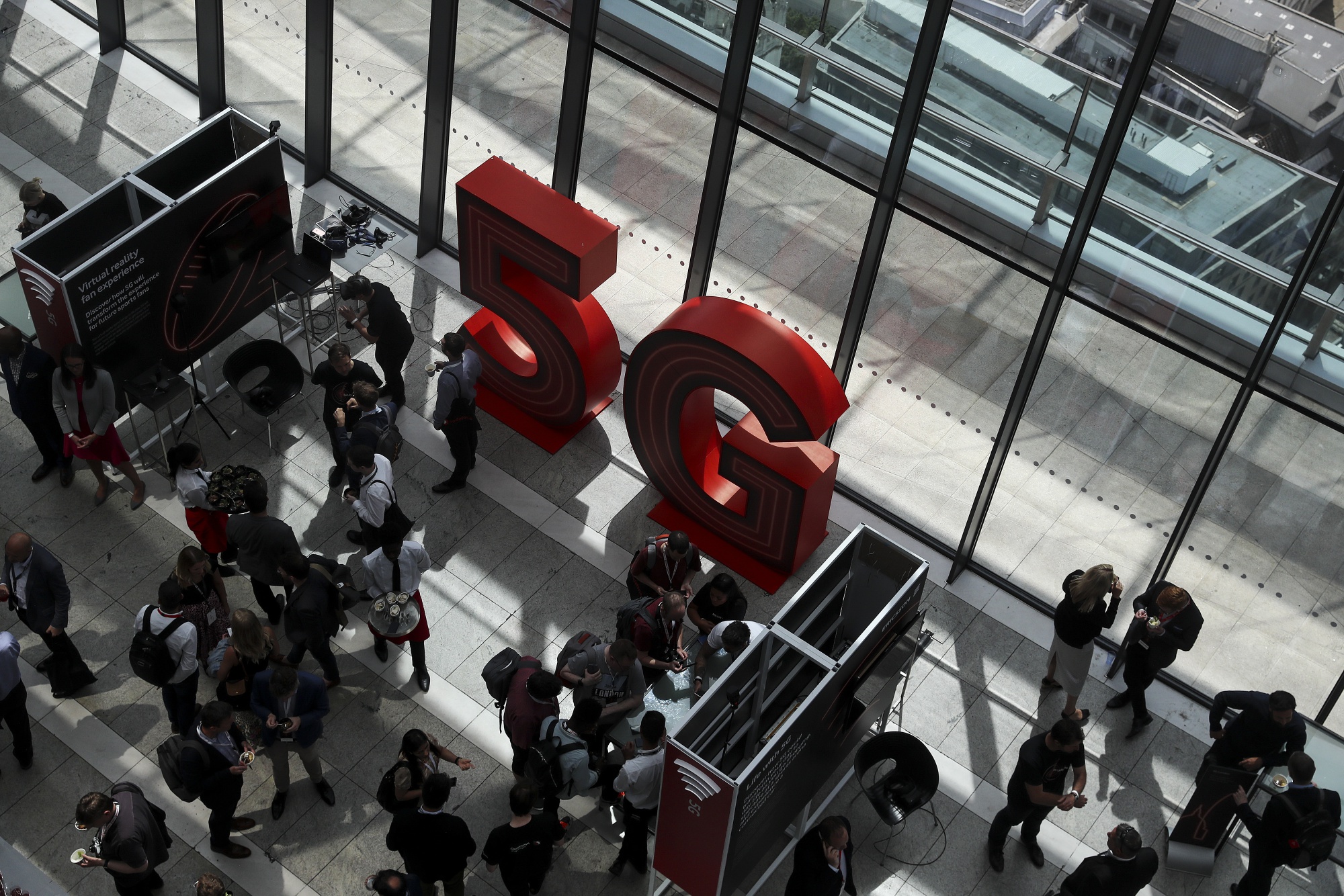 Visitors walk past 5G branding during the launch of Vodafone Group Plc's 5G wireless network in London on July 3.