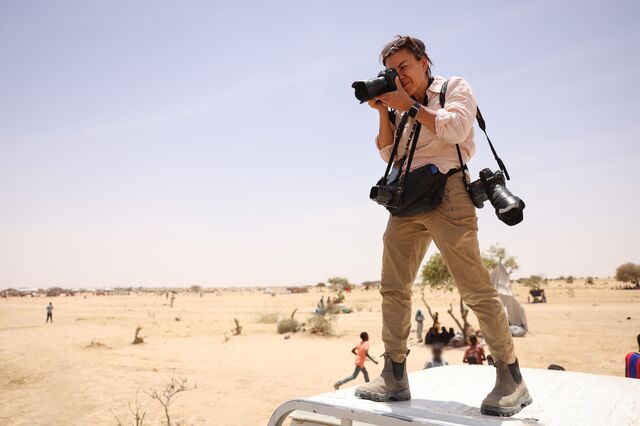 Addario on assignment in Tiné, stands on the roof of a car while taking a photograph on the Sudanese border in Northeast Chad.