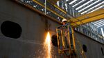 An employee uses a welding torch while working on a ship under construction at the Hyundai Heavy Industries Co. shipyard.
