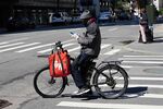 A Grubhub delivery rider checks his phone&nbsp;in New York, U.S.