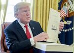 U.S. President Donald Trump with the tax-overhaul bill after singing it into law.