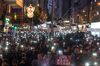 Demonstrators hold signs and shine lights from smartphones during a protest in Wan Chai district of Hong Kong.