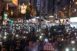 Demonstrators hold signs and shine lights from smartphones during a protest in Wan Chai district of Hong Kong.