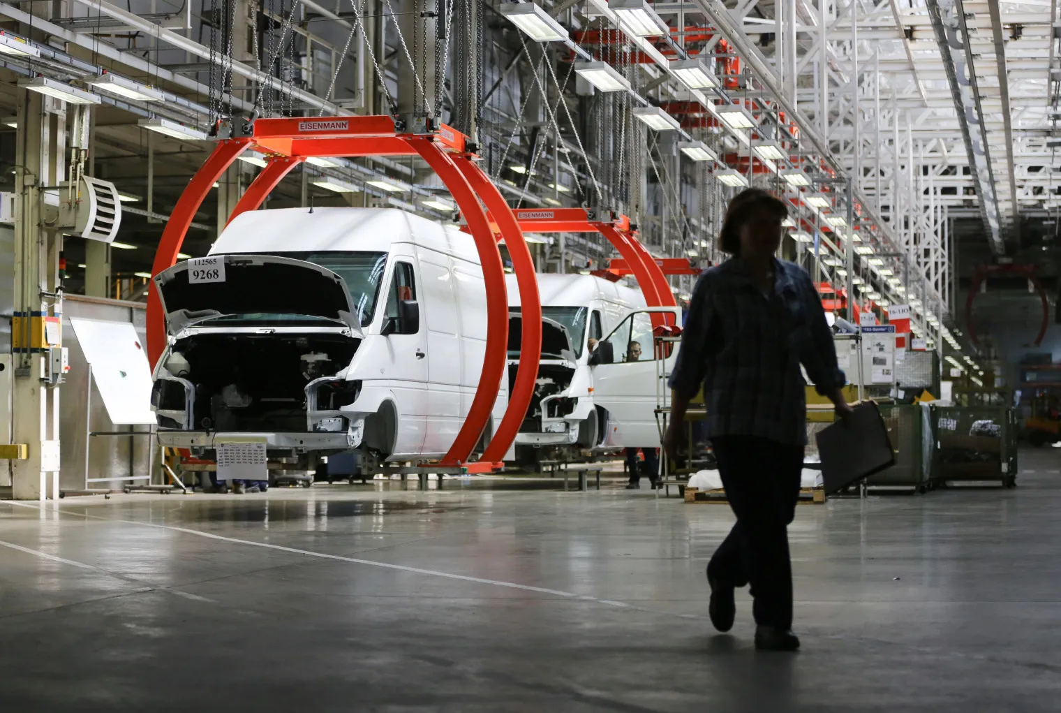 A worker passes the production line for Mercedes-Benz AG Sprinter vans.