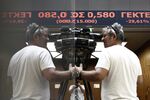 Members of the media film the stock price ticker screen following the reopening of the Athens Stock Exchange in Athens, on Monday, Aug. 3. Photographer: Kostas Tsironis/Bloomberg