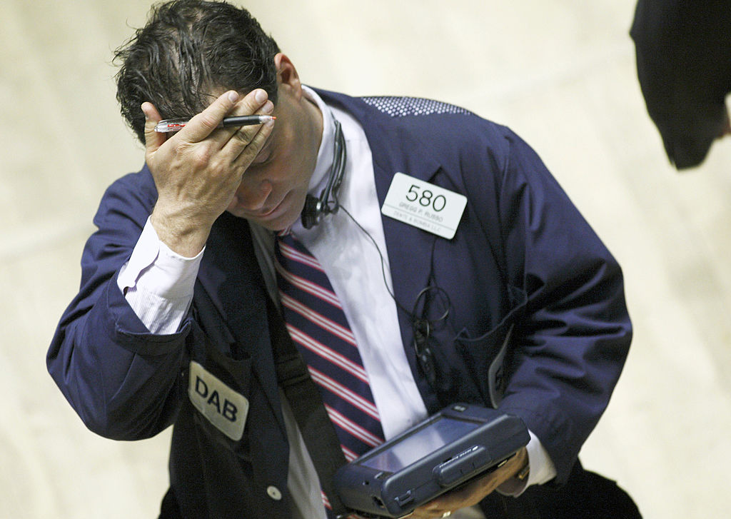 A trader rubs his forehead on the floor of the New York Stoc