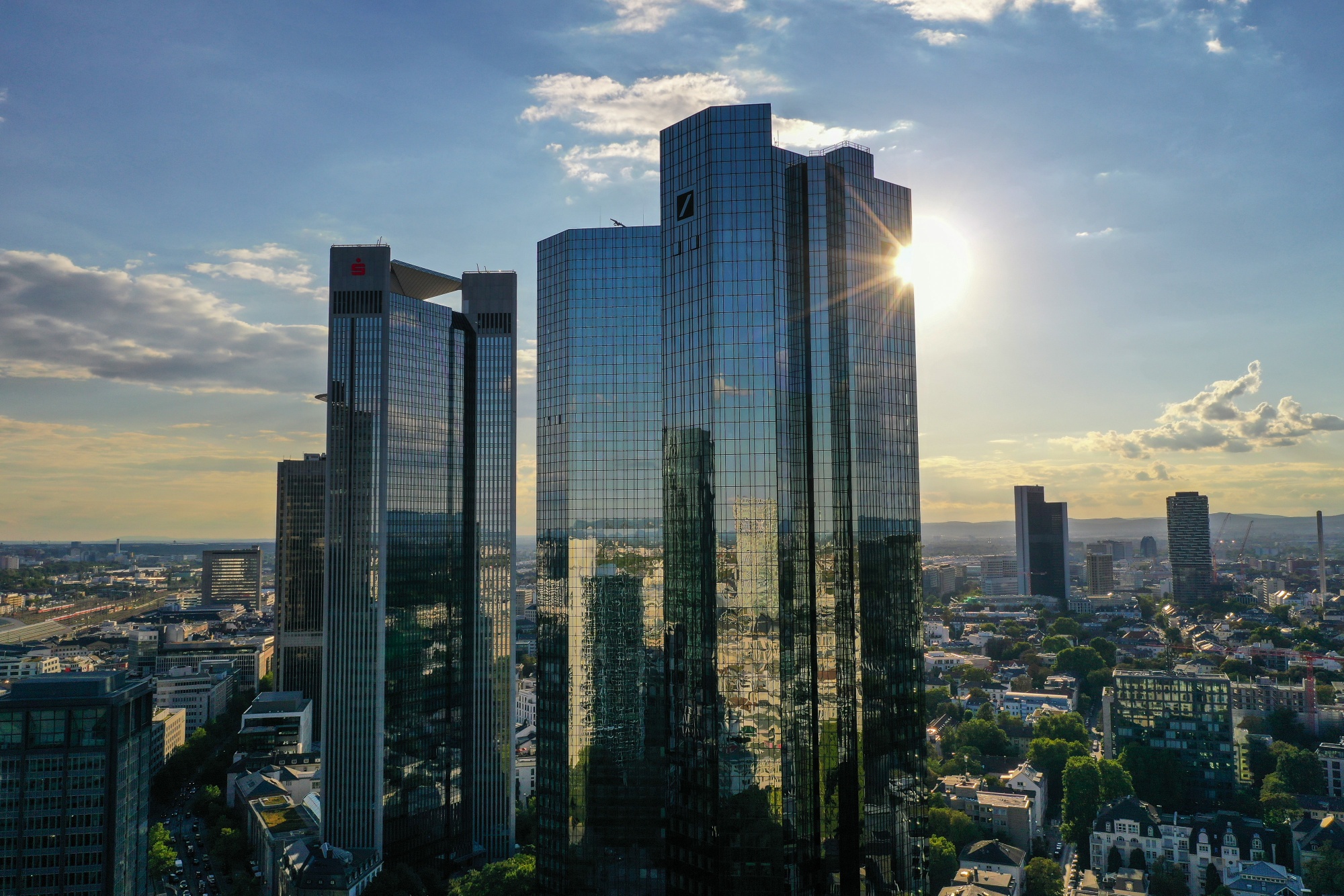 Sunlight reflects off the Deutsche Bank AG twin tower headquarters, right,&nbsp;in Frankfurt.