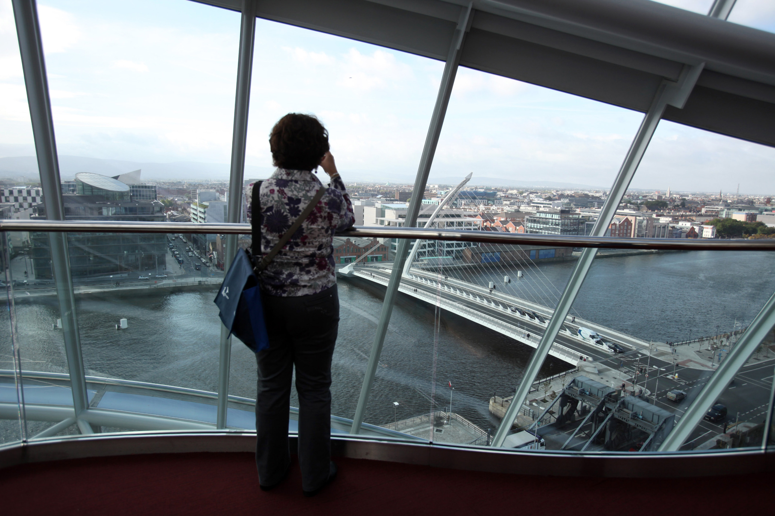 A visitor takes a photograph of the Dublin skyline from inside the Convention Centre Dublin (CCD) in Dublin, Ireland, on Monday, Sept. 20, 2010. Irish Finance Minister Brian Lenihan said the country won't need financial aid from the European Union as it prepares to sell as much as 1.5 billion euros ($2 billion) in a bond auction this week. Photographer: Crispin Rodwell