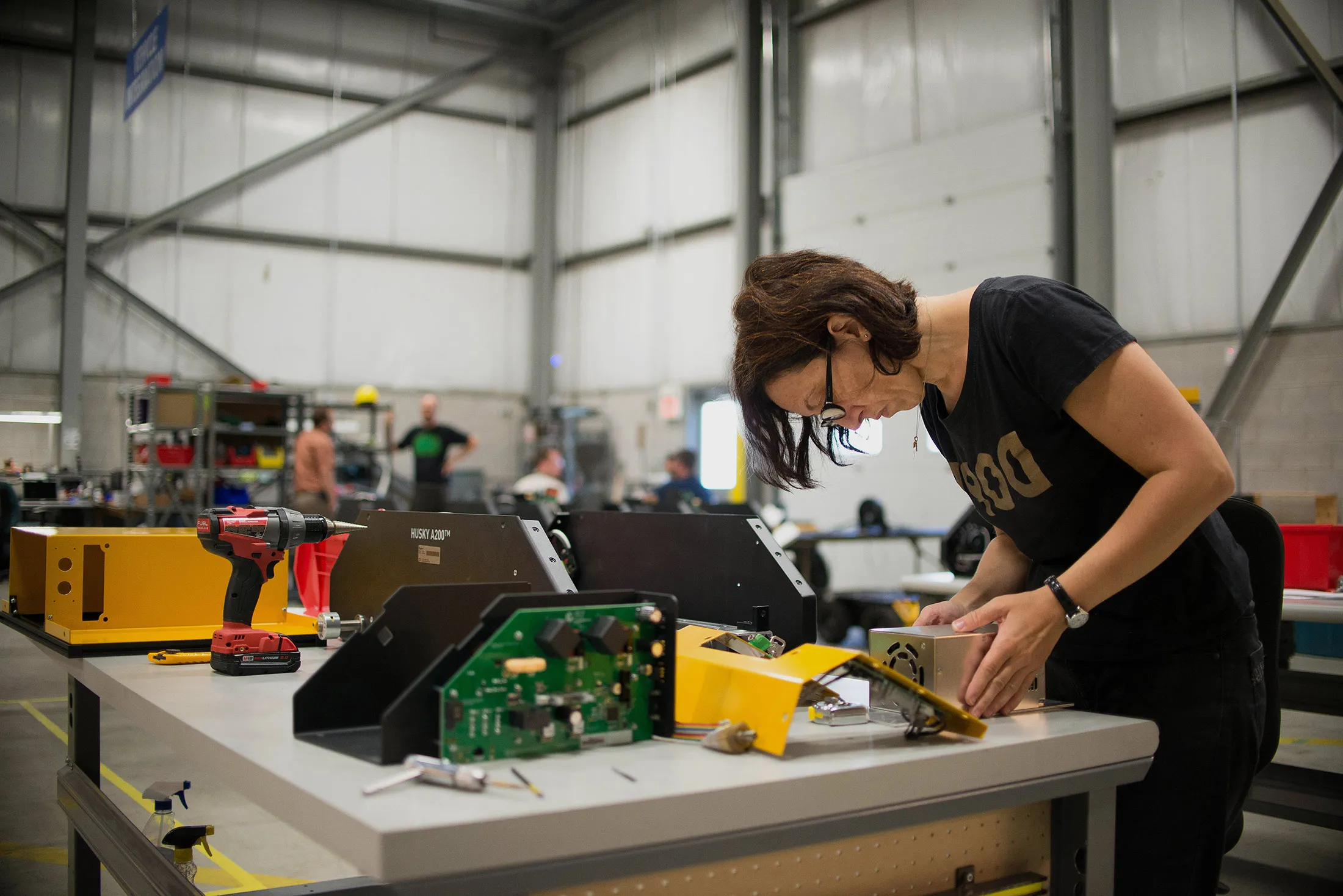 A robotics engineer hand assembles a robot model.
