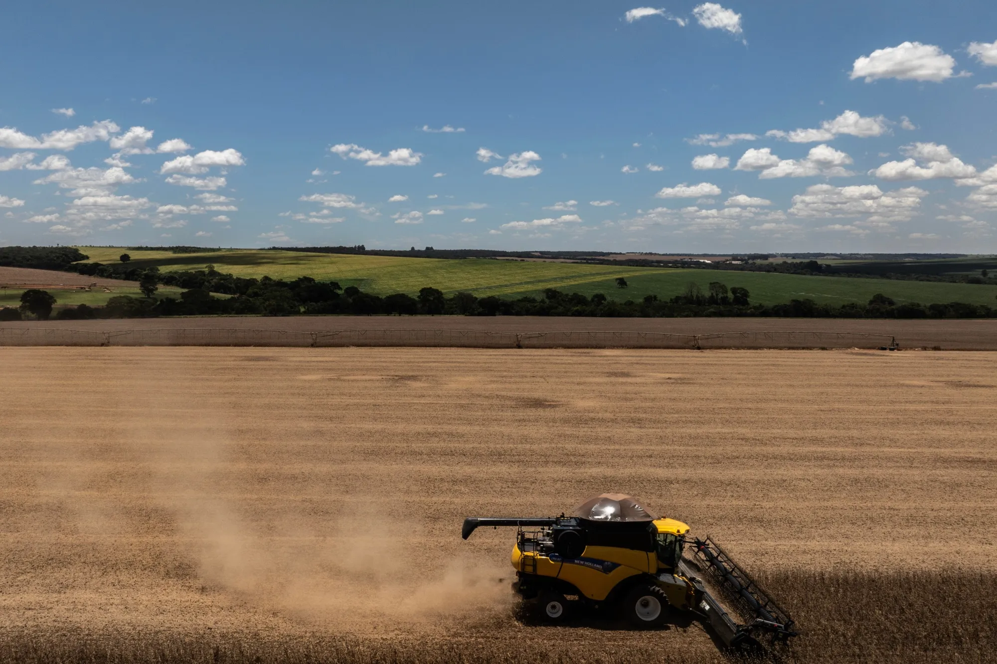 Workers use a combine harvester&nbsp;during a harvest at a soy farm in Orizona, Goias state, Brazil.