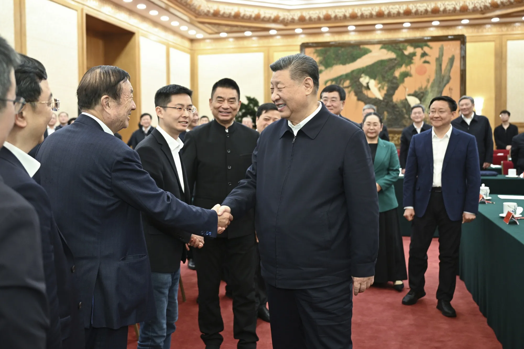 Xi Jinping shake hands with Ren Zhengfei during a meeting with private entrepreneurs in Beijing on Feb. 17.