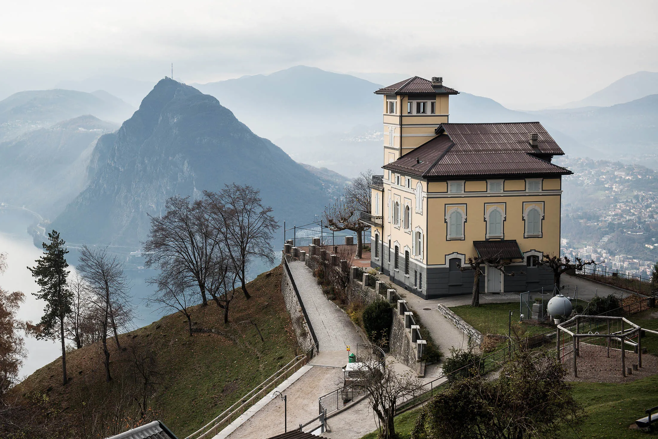 A restaurant stands on the hillside of Monte Bre overlooking the town and surrounding mountains, in Lugano, Switzerland, on Friday Nov. 20, 2015. The franc is still too strong and the economy not yet back to full health, Swiss National Bank Governing Board member Andrea Maechler said.
