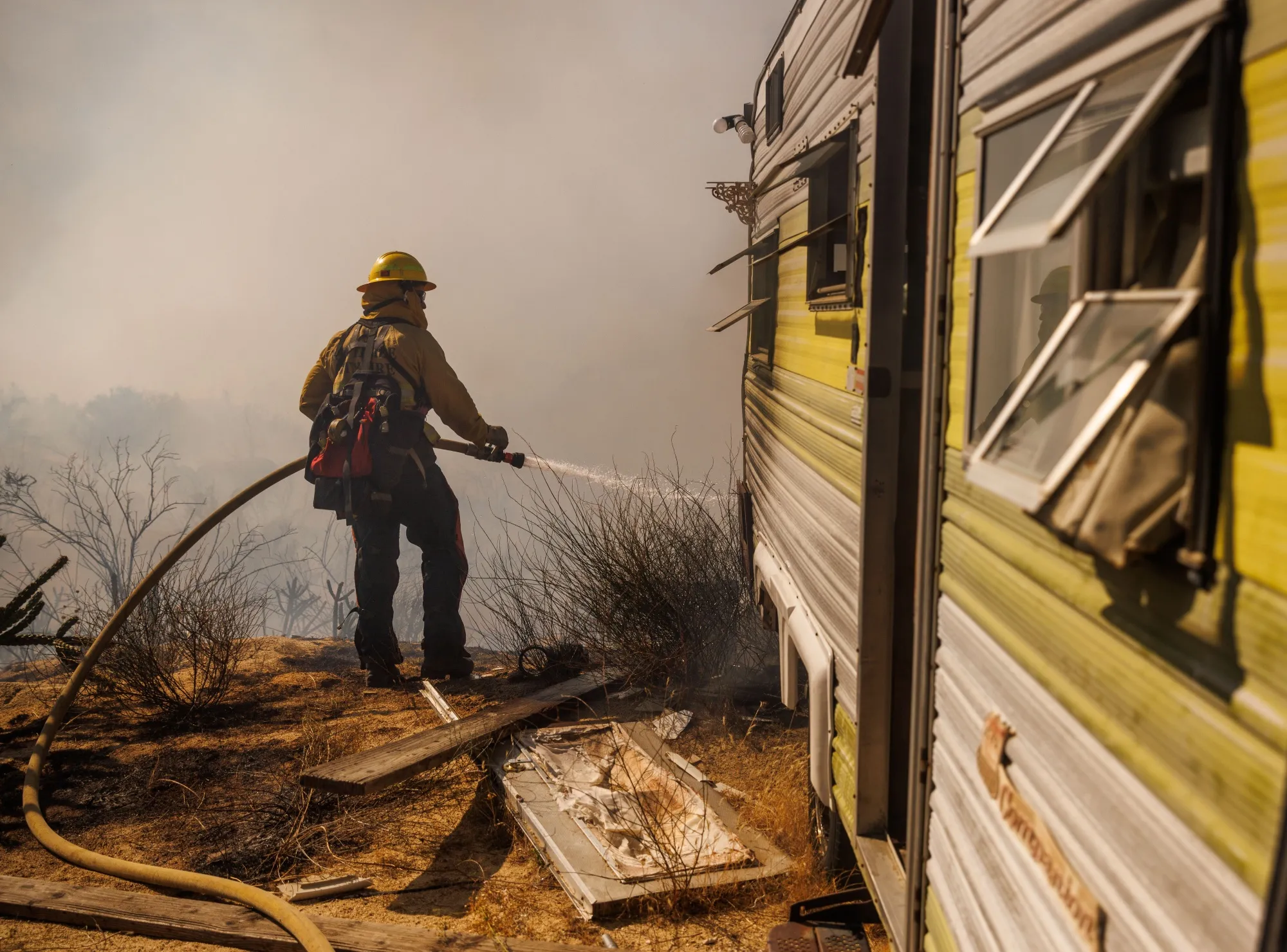A firefighter douses flames while battling the Highland Fire in Aguanga, California on&nbsp;Oct. 31.