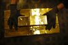A worker stacks 12.5 kilogram gold bullion bars at the Valcambi SA precious metal refinery in Balerna, Switzerland.