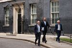 Chair of the OBR, Richard Hughes, left, Andy King, center, and Professor&nbsp;David Miles depart Downing Street after a meeting with Liz Truss on Sept. 30.