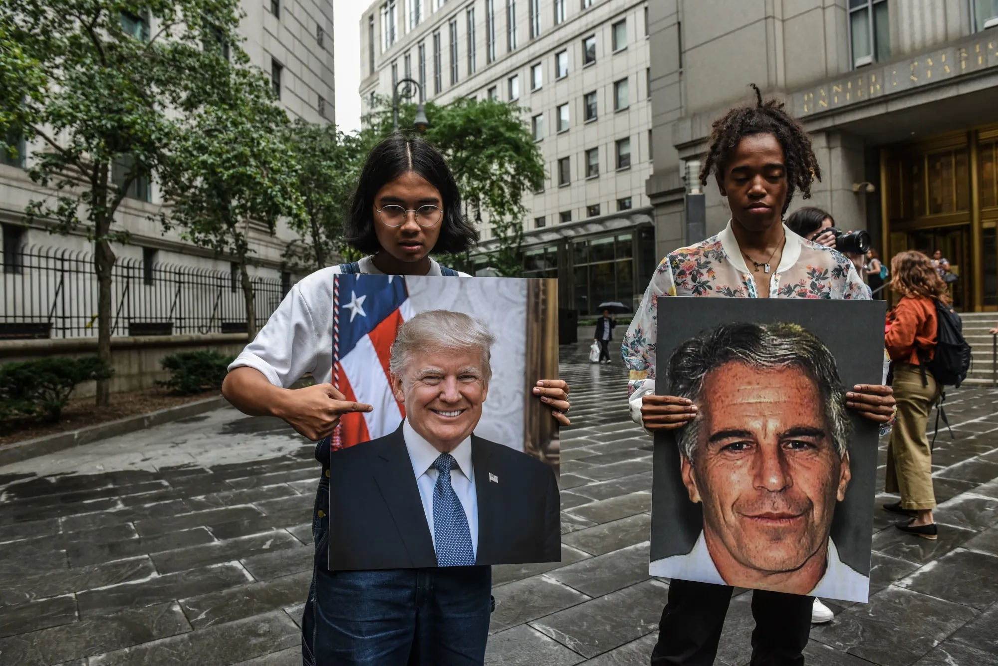 Protesters hold images of Jeffrey Epstein and Donald Trump in front of the Federal courthouse in New York in July 2019.