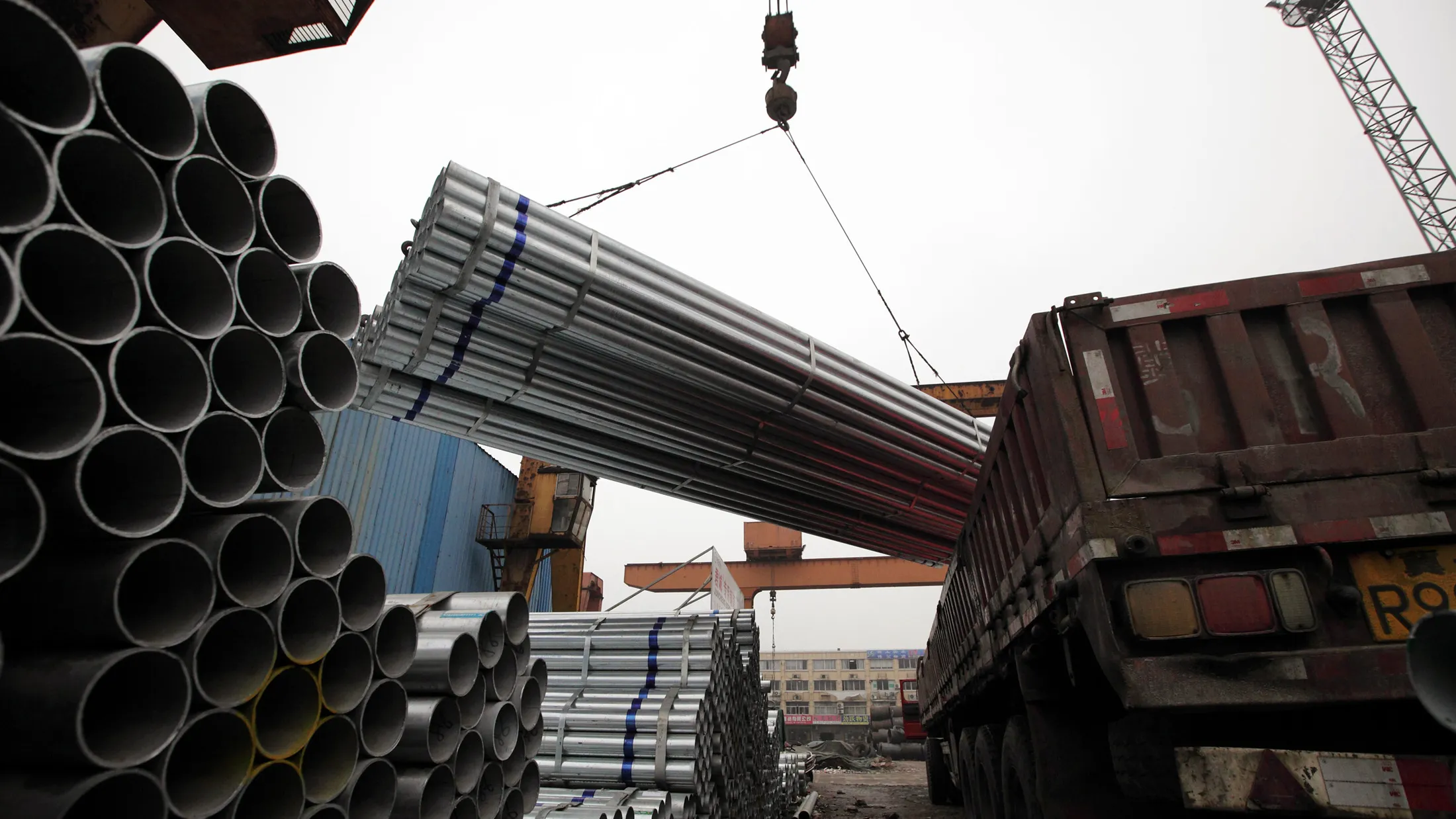 Steel pipes are loaded onto a truck at a storage yard in Shanghai.
