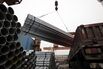 Steel pipes are loaded onto a truck at a storage yard in Shanghai.
