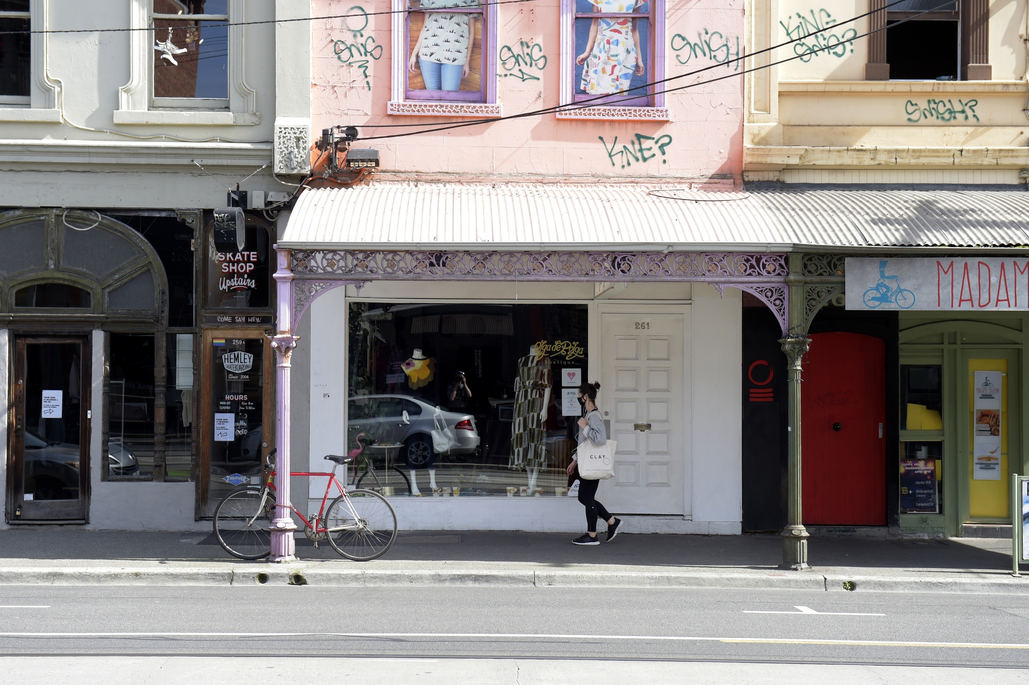 A pedestrian wearing a protective mask walks past a closed store in Melbourne, on Sept. 1.