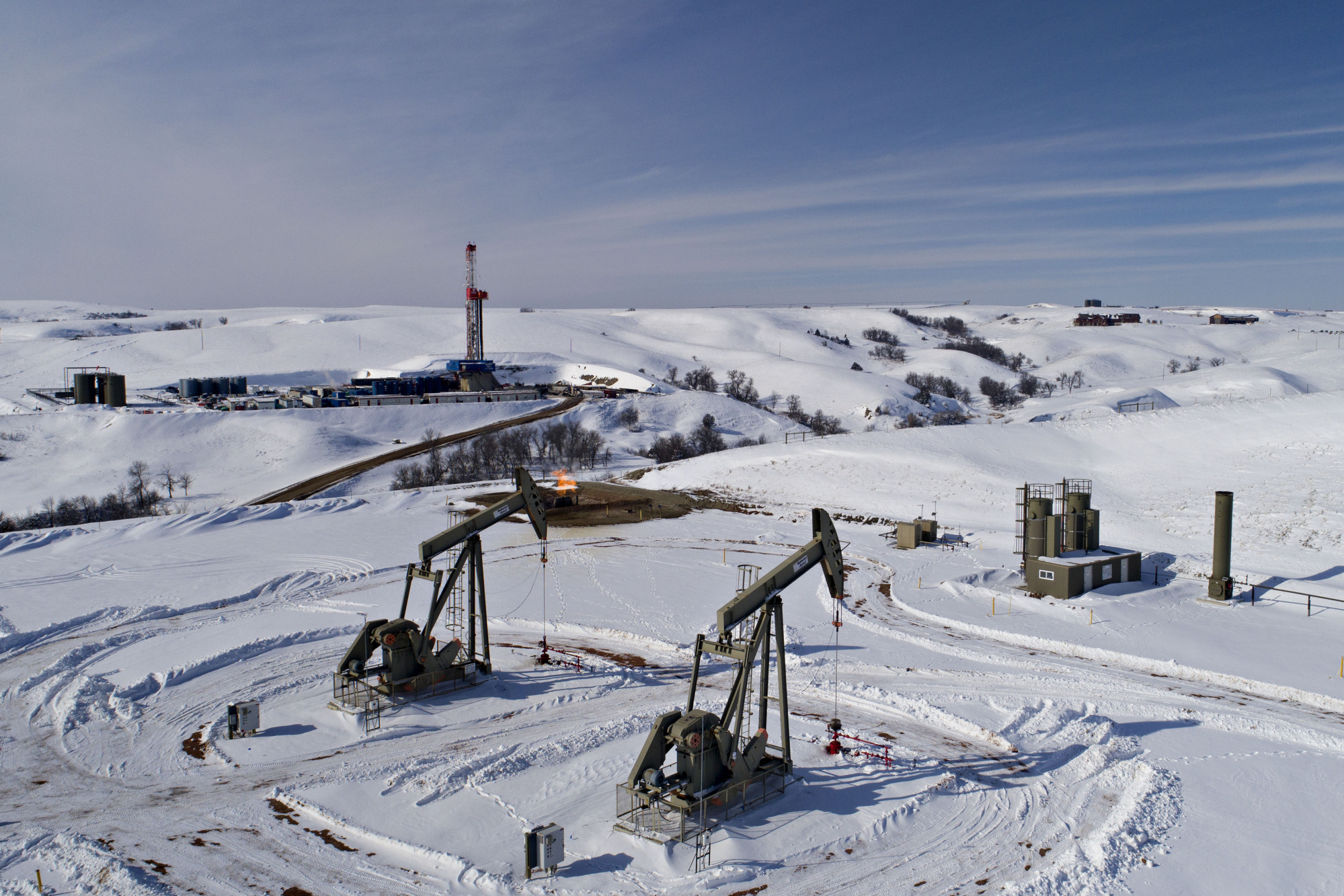Pumpjacks and a drill rig in the Bakken Formation in Williston, North Dakota, in 2018.
