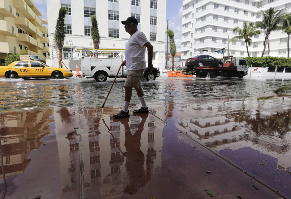 Louis Fernandez walks along a flooded Collins Ave. from his apartment to a nearby restaurant in Miami Beach, Florida.