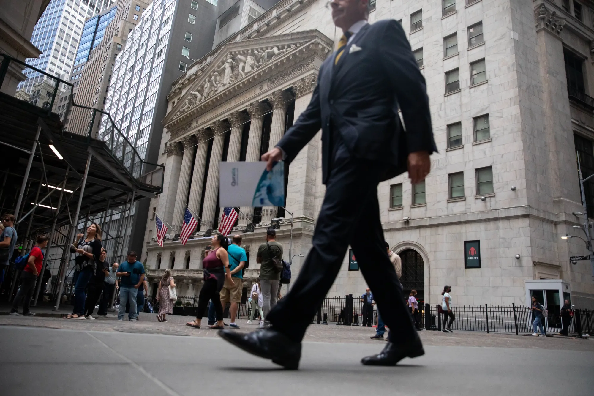 Pedestrians pass in front of the New York Stock Exchange in New York, U.S.