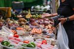 A customer pays for fresh produce at a grocery stall on Surrey Street Market in Croydon, UK.