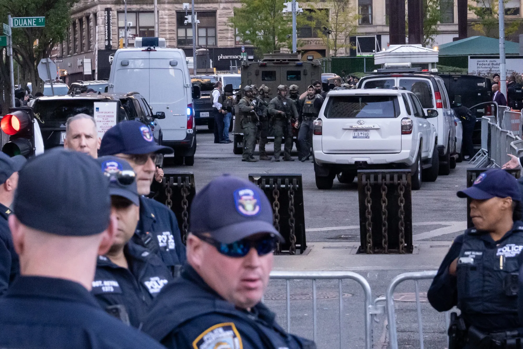 Heavily armed federal agents stand by an armored vehicle as NYPD Strategic Response Group&nbsp;agents stand by outside of 26 Federal Plaza on Oct. 21, 2025 in New York.
