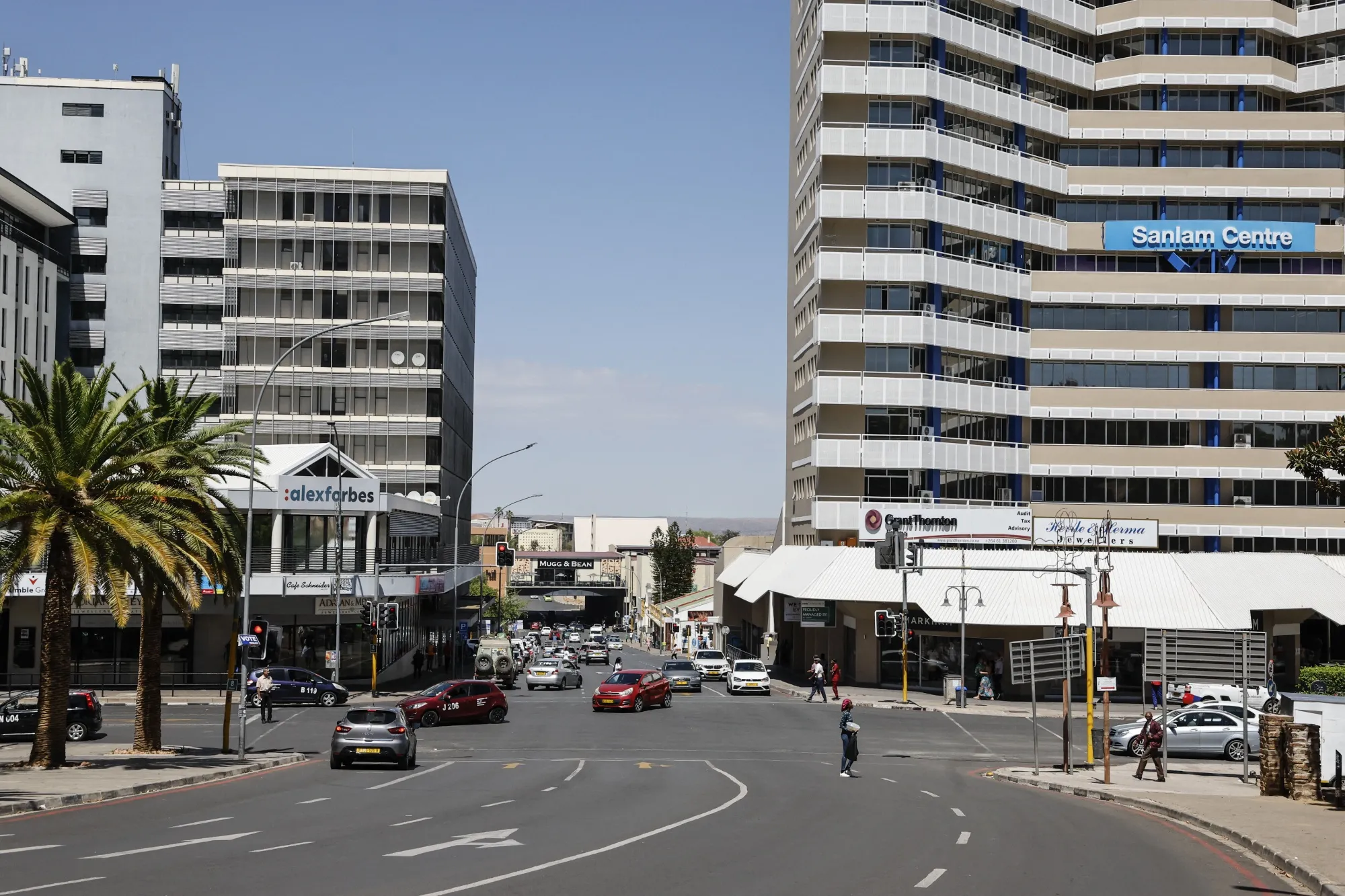 Pedestrians walk across a street in Windhoek, Namibia.