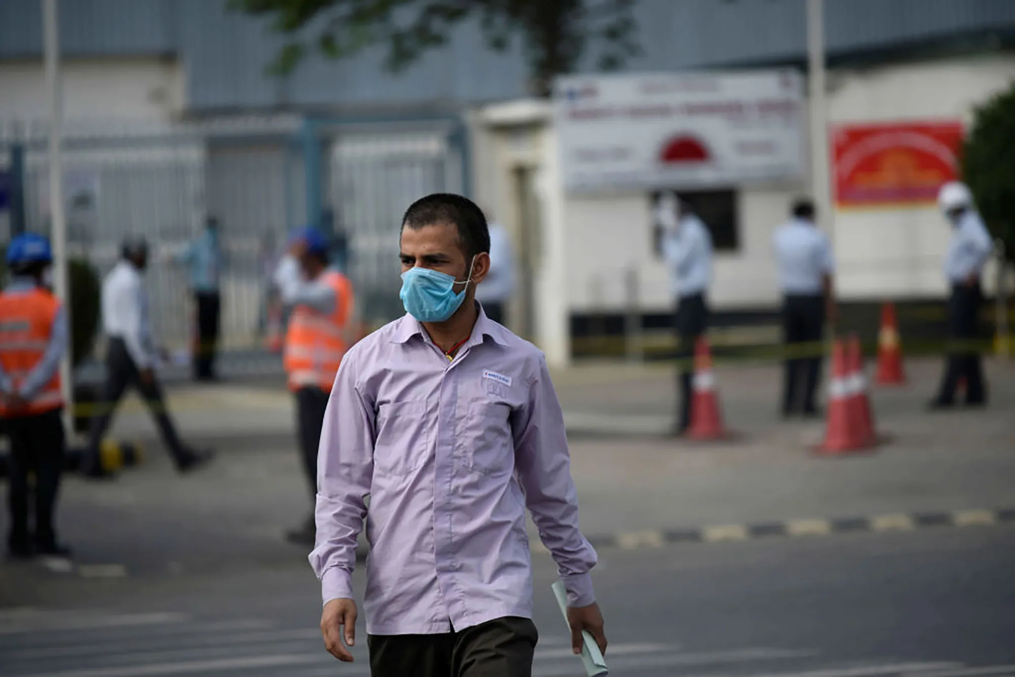 An employee at an Indian factory in lockdown outside the plant.