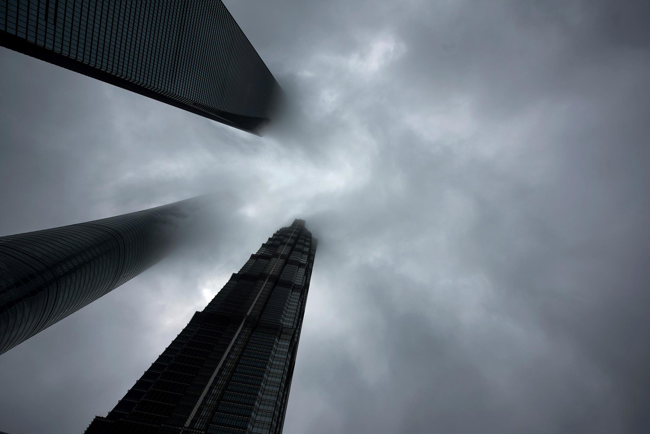 Clouds are seen around the Shanghai World Financial Center in Shanghai on April 6, 2016.
