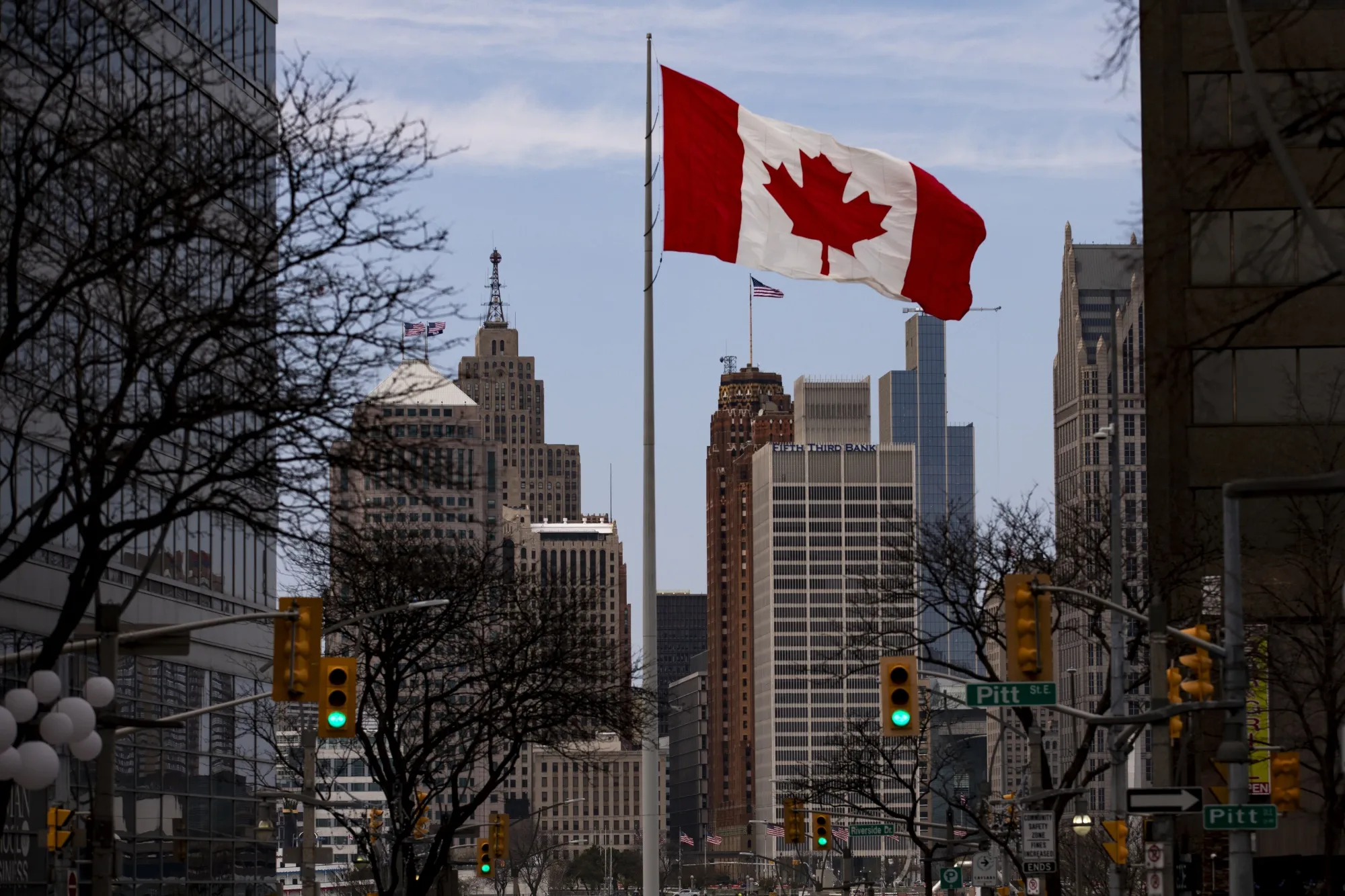 A Canadian flag flies in downtown Windsor, Ontario, with the skyline of Detroit in the background.&nbsp;