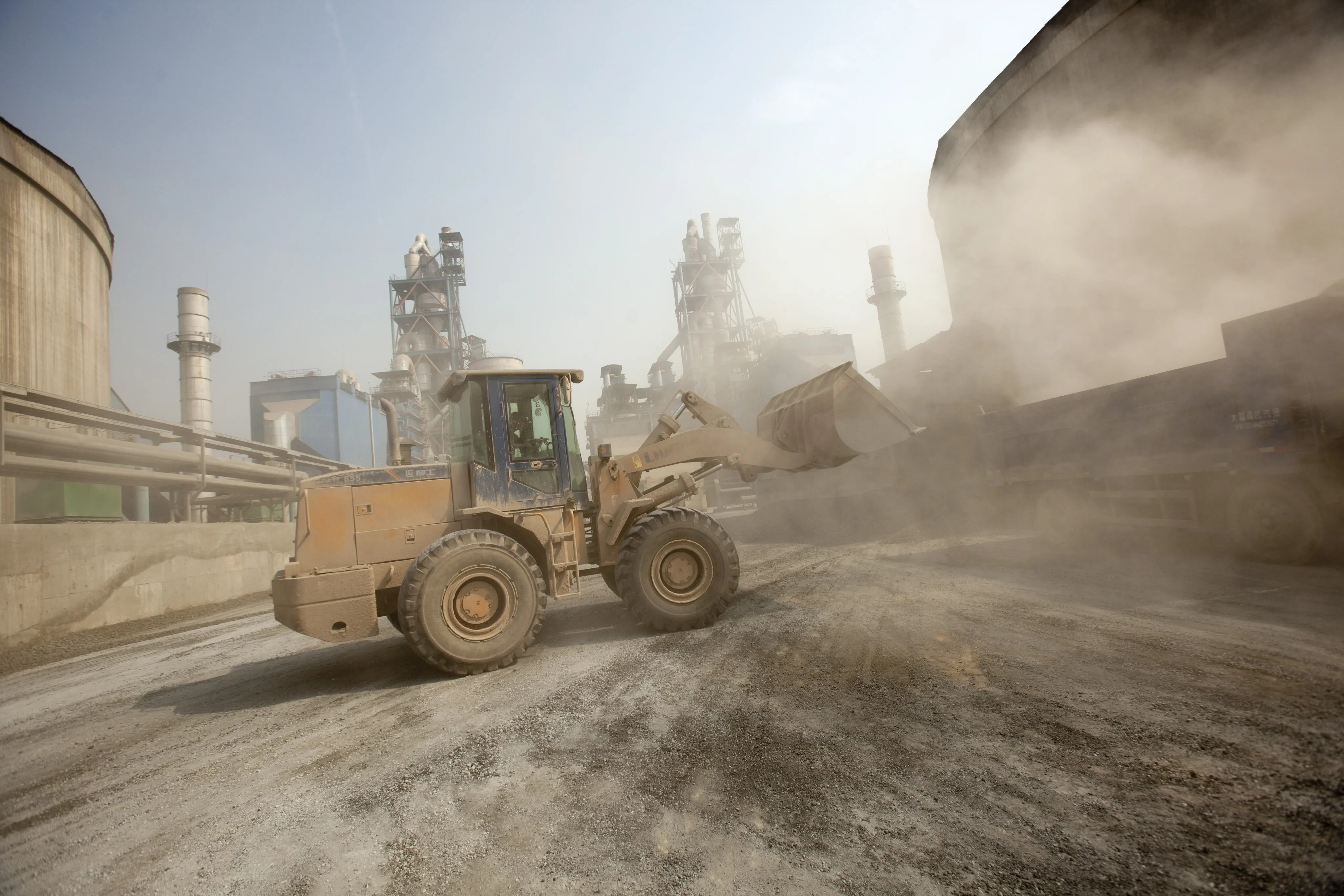 Heavy machinery loads a truck with materials for producing cement at the West China Cement Ltd. plant in Xian, China.