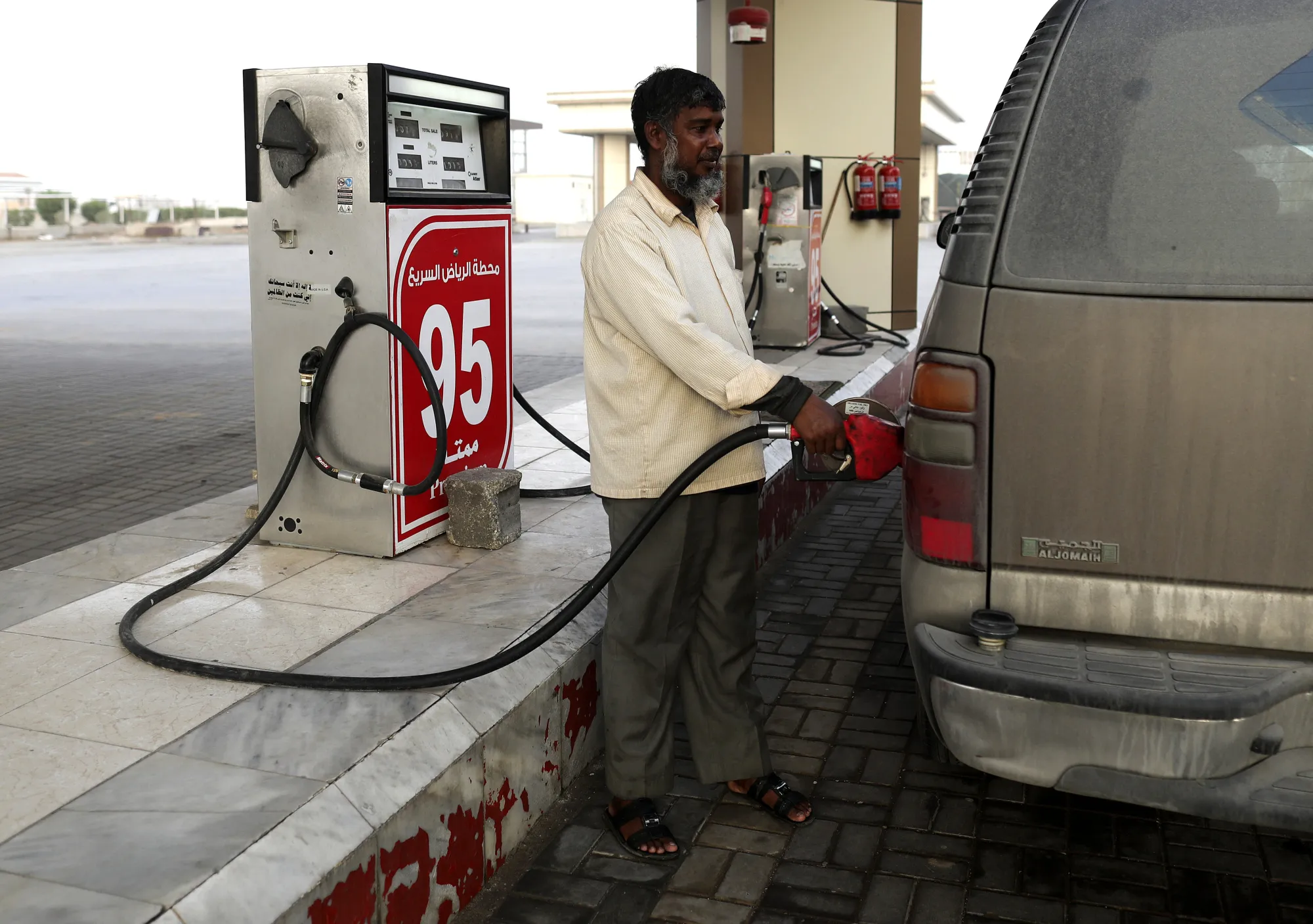 A man fills a vehicle with gas near the city of Qassim, north west of Riyadh.
