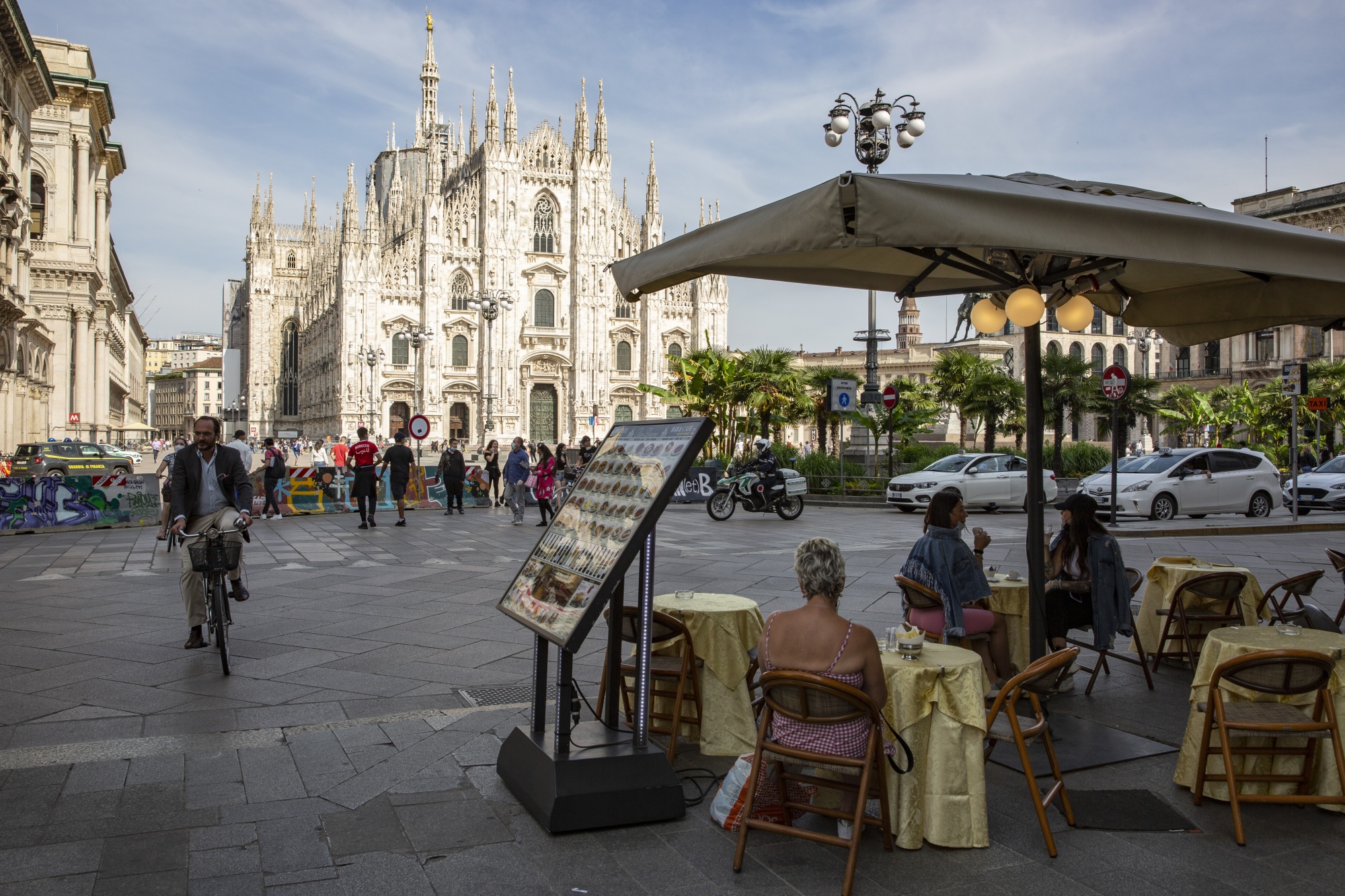 People eat at a restaurant in the Cathedral square in Milan.